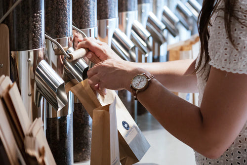 Pouring whole bean coffee from our tubes to a bag