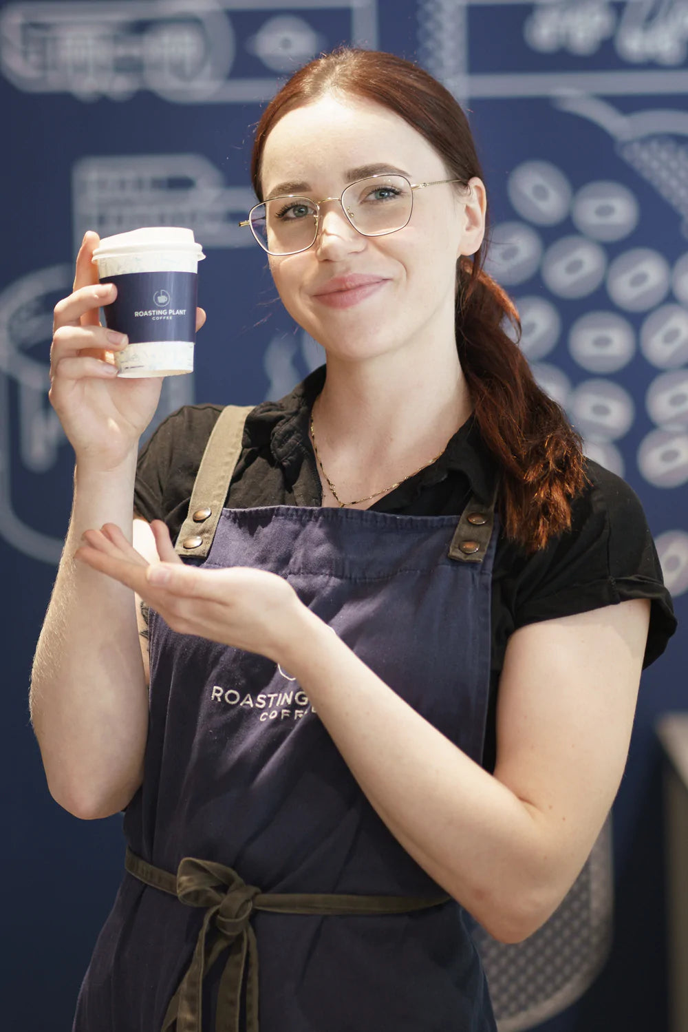Barista holding up a to-go coffee